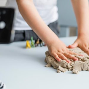 close-up-hands-playing-with-sand_23-2148551536